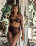 Woman wearing a brown bikini set in a tropical setting