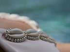 Shell and bead bikini top detail with a blurred natural background
